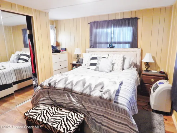 a bedroom with a bed and wooden floor