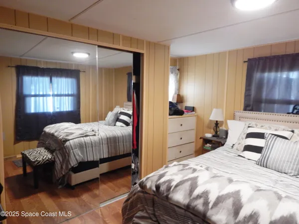 a bedroom with a bed and wooden floor