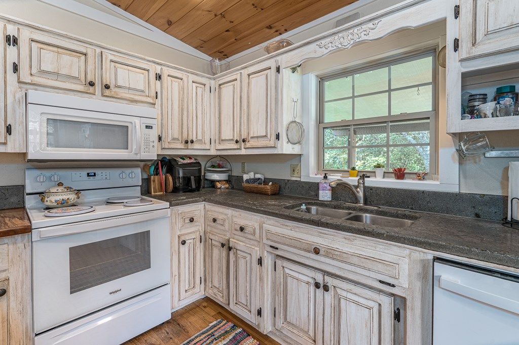 264 Tommy's Lane Murphy, NC 28906 - Photo 18 of 53 a kitchen with granite countertop white cabinets and white appliances