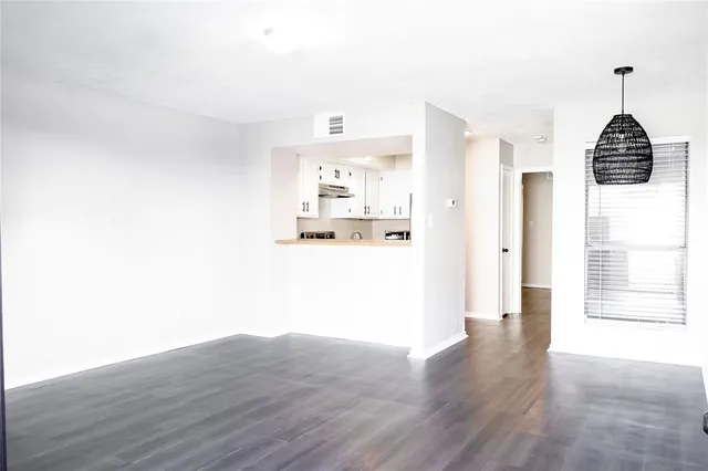 a view of a hallway with wooden floor and a cabinet