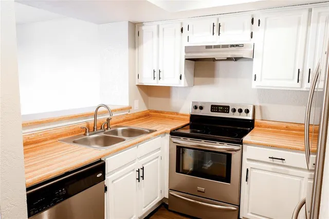 a kitchen with stainless steel appliances granite countertop a sink and a stove