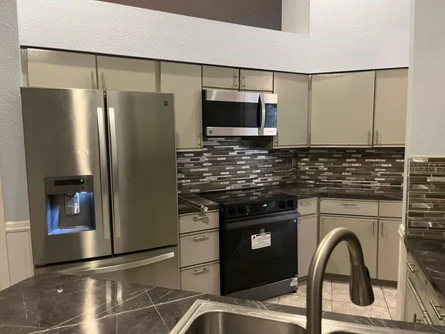 a kitchen with a refrigerator and a sink