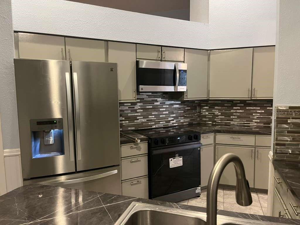 417 Greenfield Road Winter Haven, FL 33884 - Photo 7 of 15 a kitchen with a refrigerator and a sink