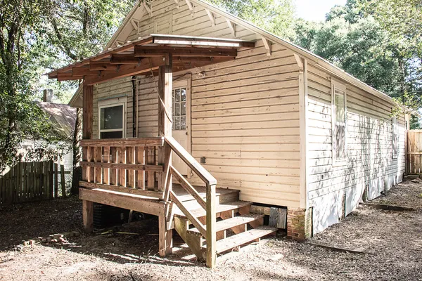 a view of wooden house with a yard