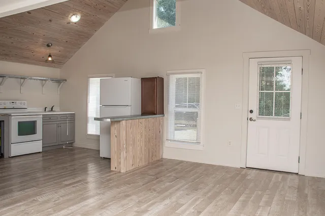 a kitchen with stainless steel appliances granite countertop a stove a sink and a refrigerator with wooden floors