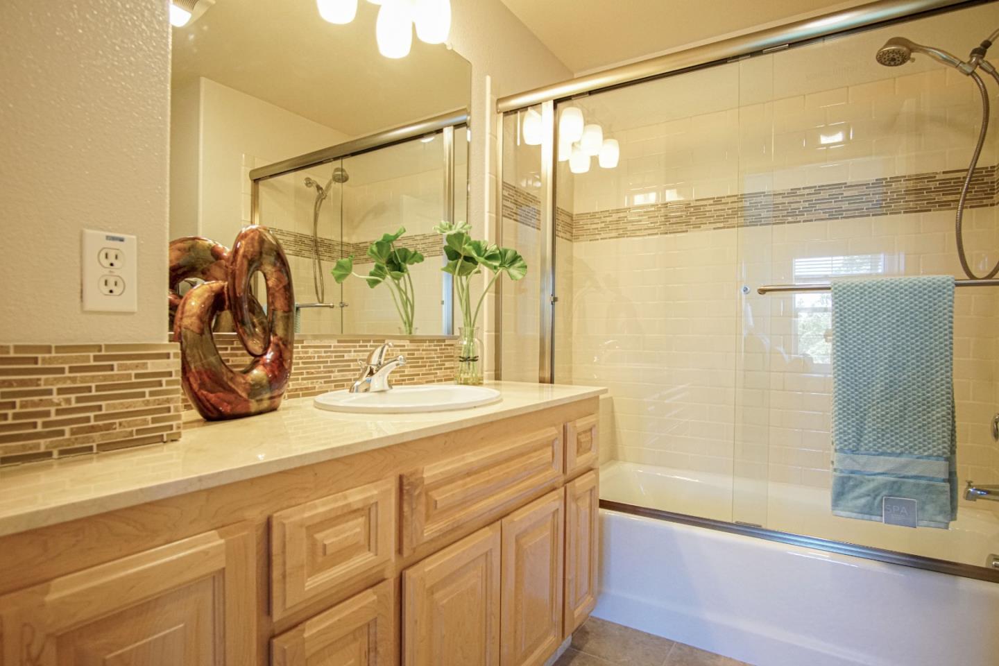 3906 Borgo Common Fremont, CA 94538 - Photo 11 of 21 a bathroom with a granite countertop sink mirror and a shower