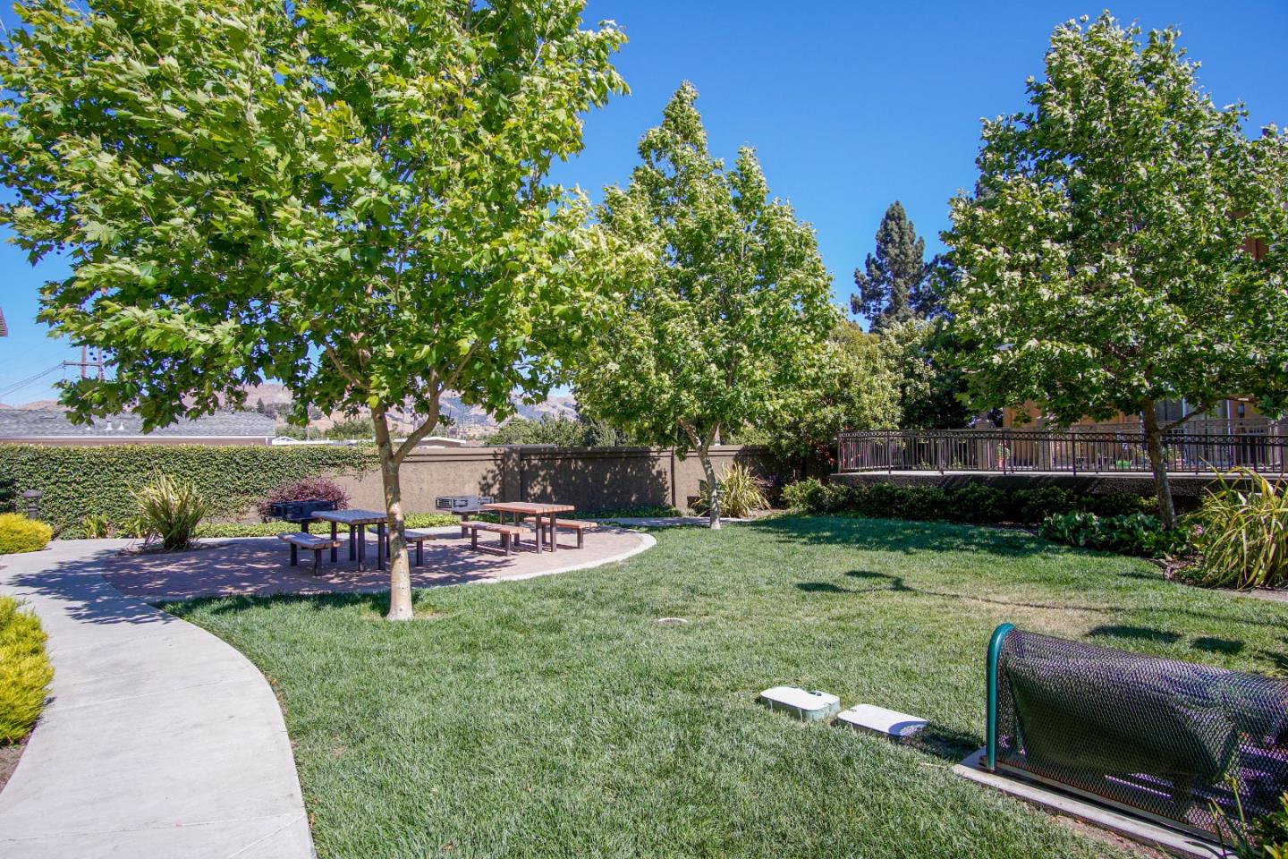 3906 Borgo Common Fremont, CA 94538 - Photo 21 of 21 an outdoor sitting area with a table and chairs under an umbrella