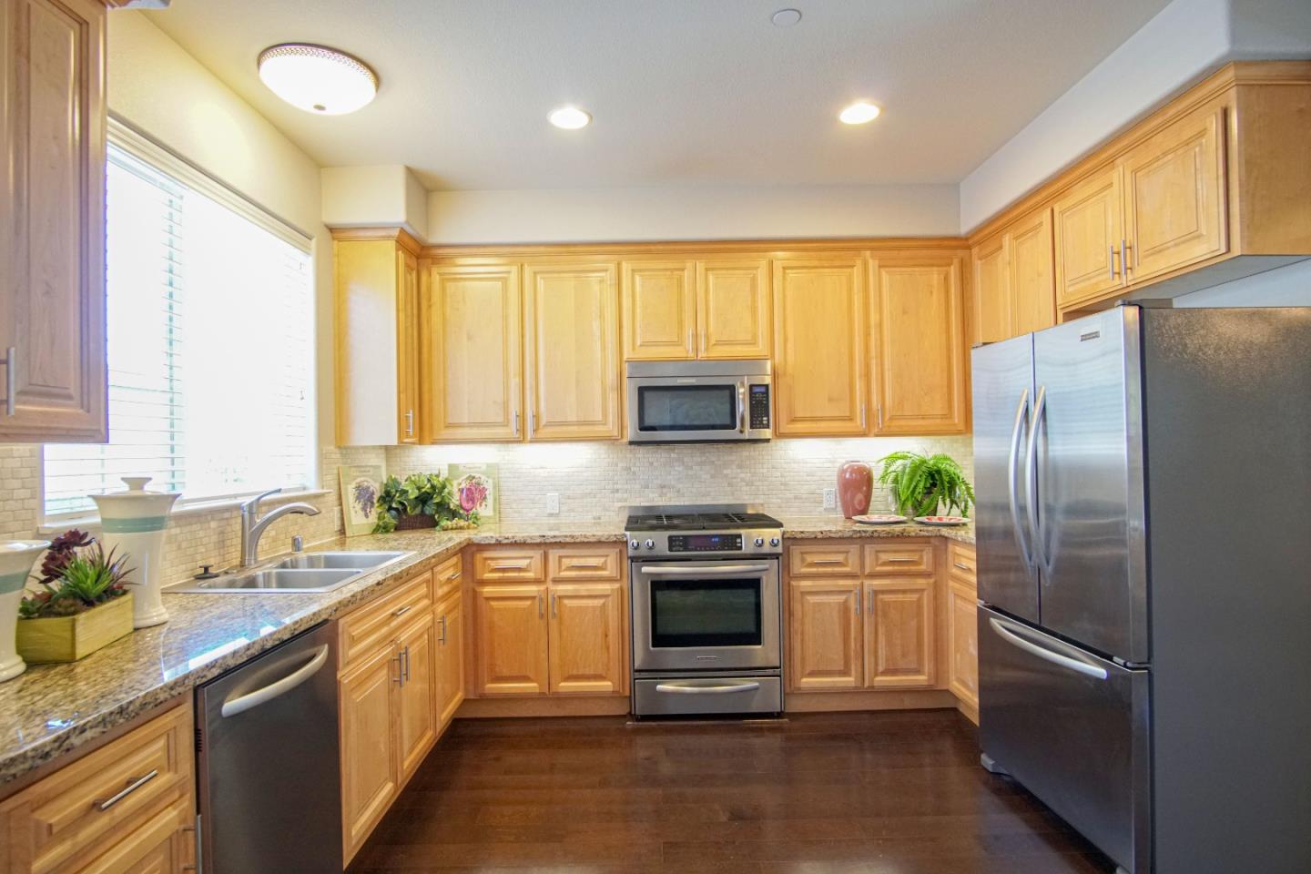 3906 Borgo Common Fremont, CA 94538 - Photo 7 of 21 a kitchen with a sink a refrigerator and cabinets