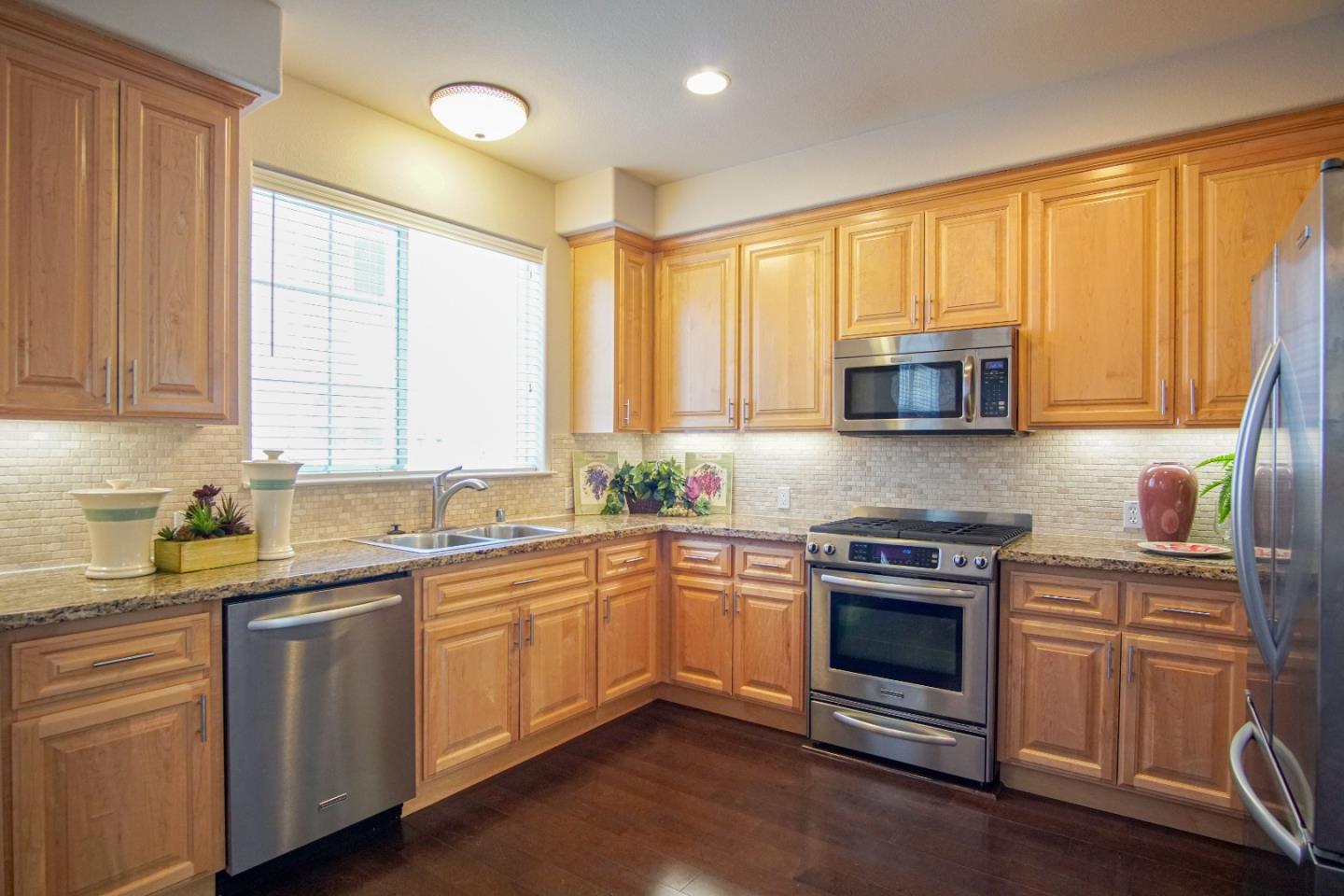 3906 Borgo Common Fremont, CA 94538 - Photo 8 of 21 a kitchen with stainless steel appliances granite countertop white cabinets a sink and a stove