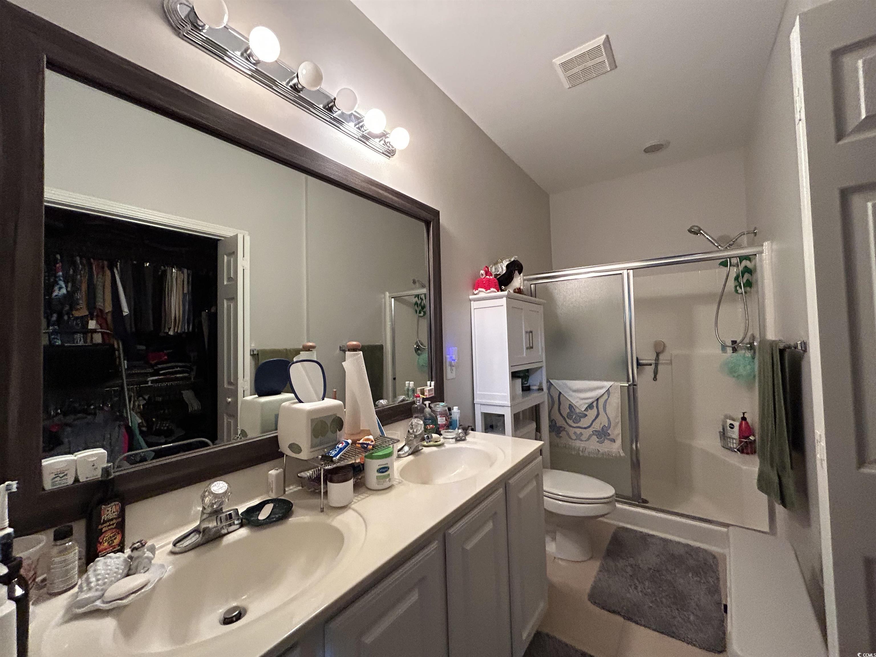 1525 Lanterns Rest Road, Unit 301 Myrtle Beach, SC 29579 - Photo 9 of 34 Bathroom featuring toilet, a shower with shower door, vanity, and tile patterned flooring