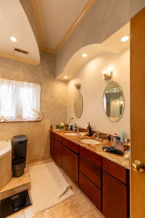 a bathroom with a double vanity sink mirror and toilet