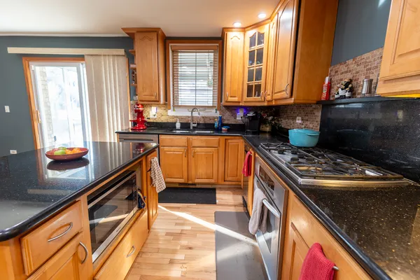 a kitchen with stainless steel appliances granite countertop a stove a sink and a microwave