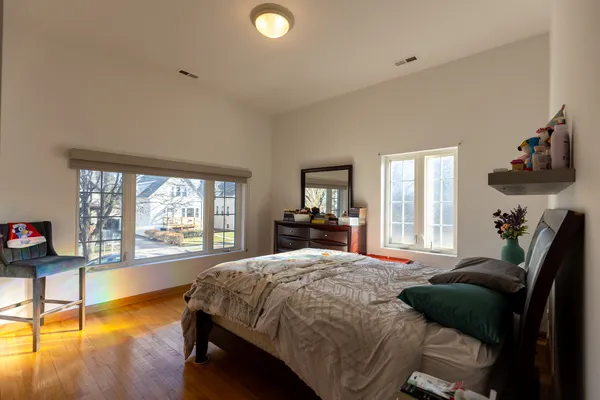 a bedroom with a bed and wooden floor
