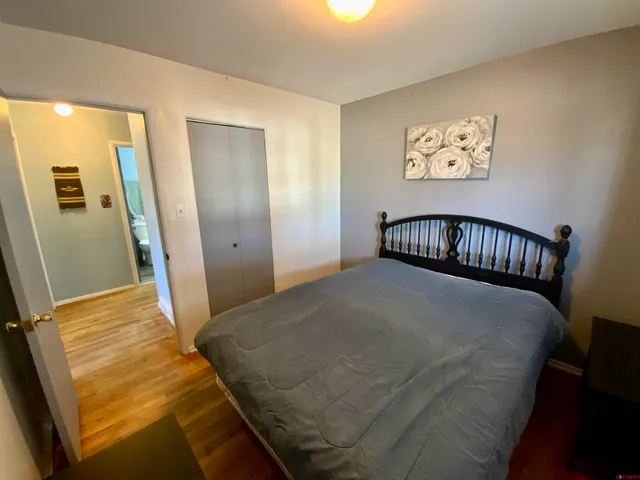 a bedroom with a bed and wooden floor