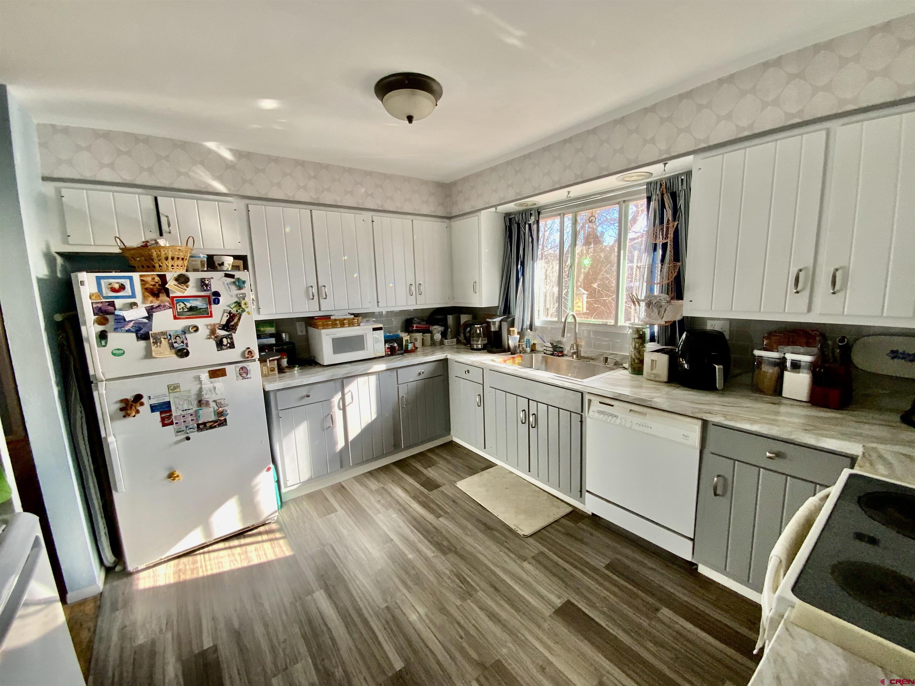 21 Vulcan Street Gunnison, CO 81230 - Photo 6 of 21 a kitchen with stainless steel appliances granite countertop a refrigerator sink and wooden cabinets