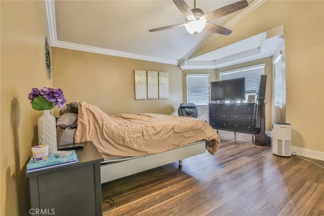 a bedroom with a bed and a chandelier fan