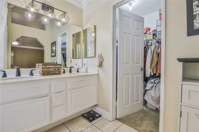 a en suite bathroom with a double vanity sink mirror and toilet