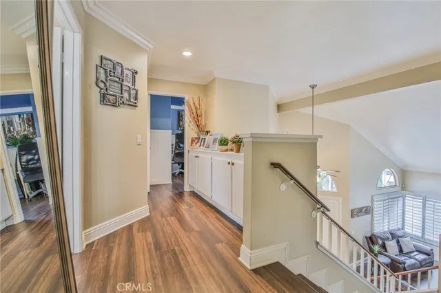 a view of a hallway with wooden floor and staircase