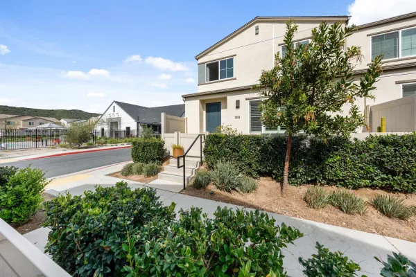 a front view of a house with a yard and potted plants