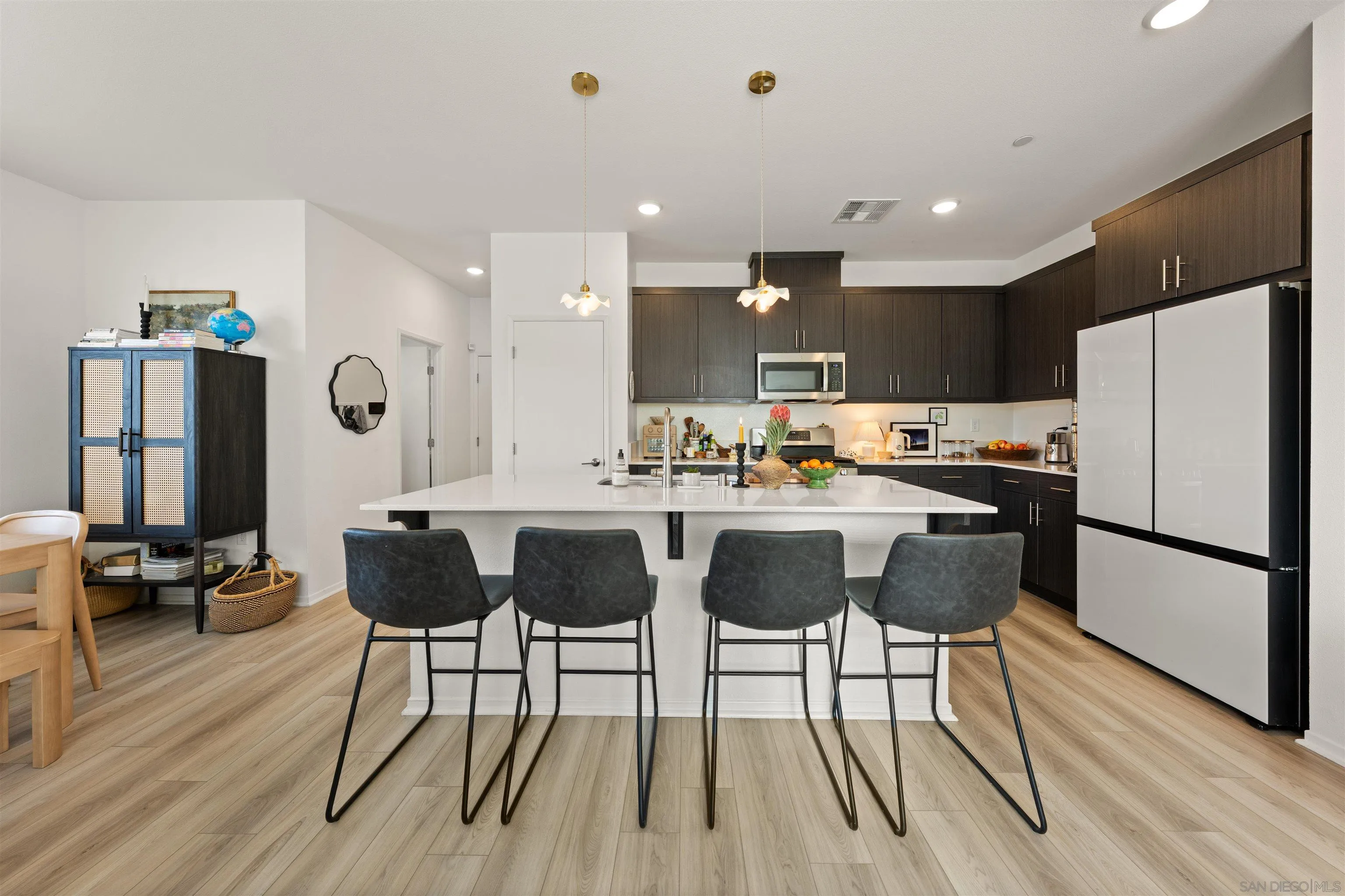 303 Citrine Trail Fallbrook, CA 92028 - Photo 10 of 47 a kitchen with stainless steel appliances kitchen island granite countertop a table chairs and a refrigerator