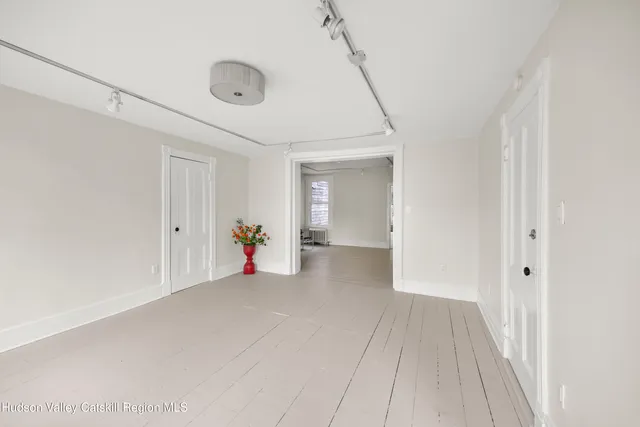 a hallway with wooden floor and furniture