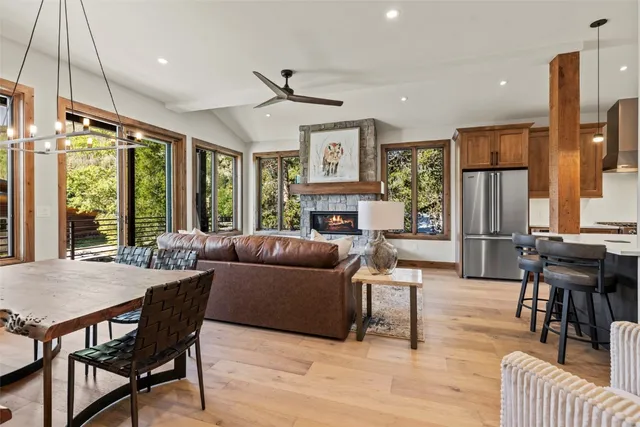 a living room with furniture a large window and wooden floor