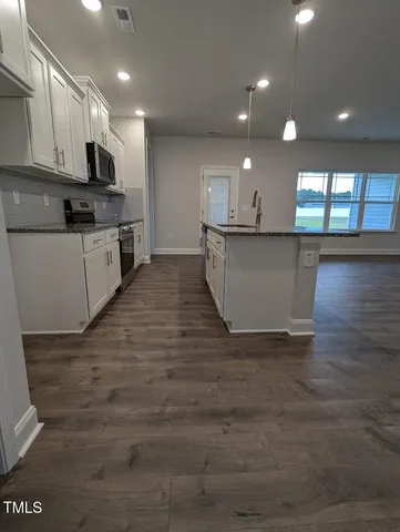 a view of kitchen with microwave and cabinets