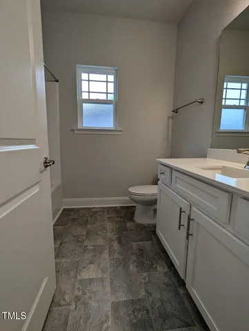 a bathroom with a sink a toilet and a window