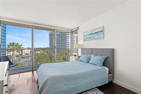 a bedroom with a large window and a balcony