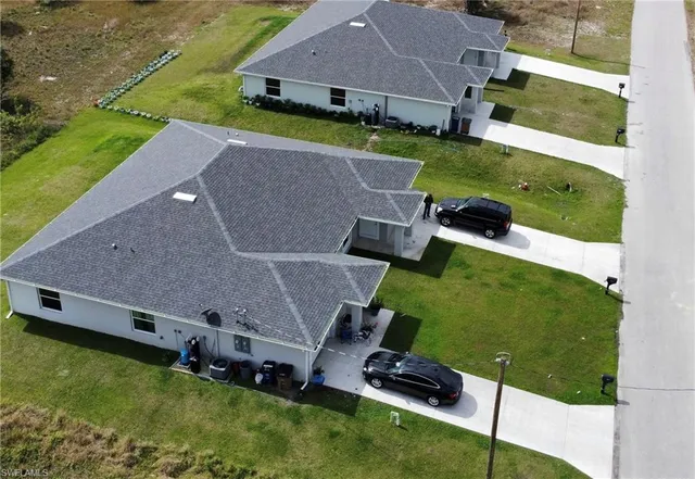 an aerial view of a house with swimming pool and yard