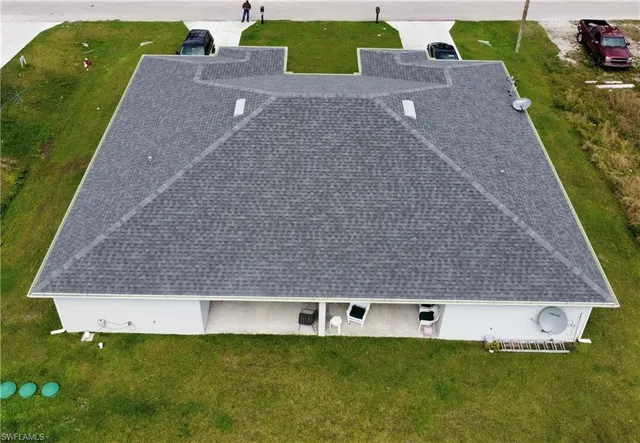a front view of house with a garden and parking