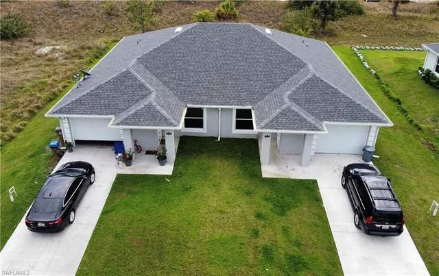a view of a house with a swimming pool and a yard