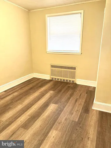 a view of a room with wooden floor and a window