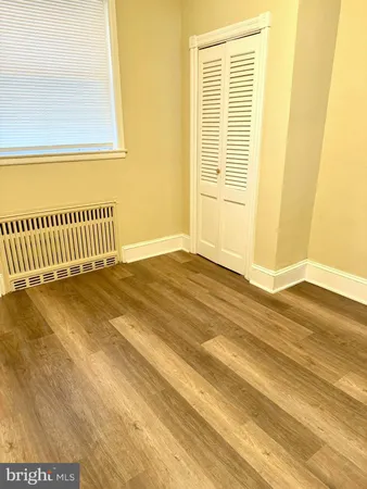 a view of a room with wooden floor and a window