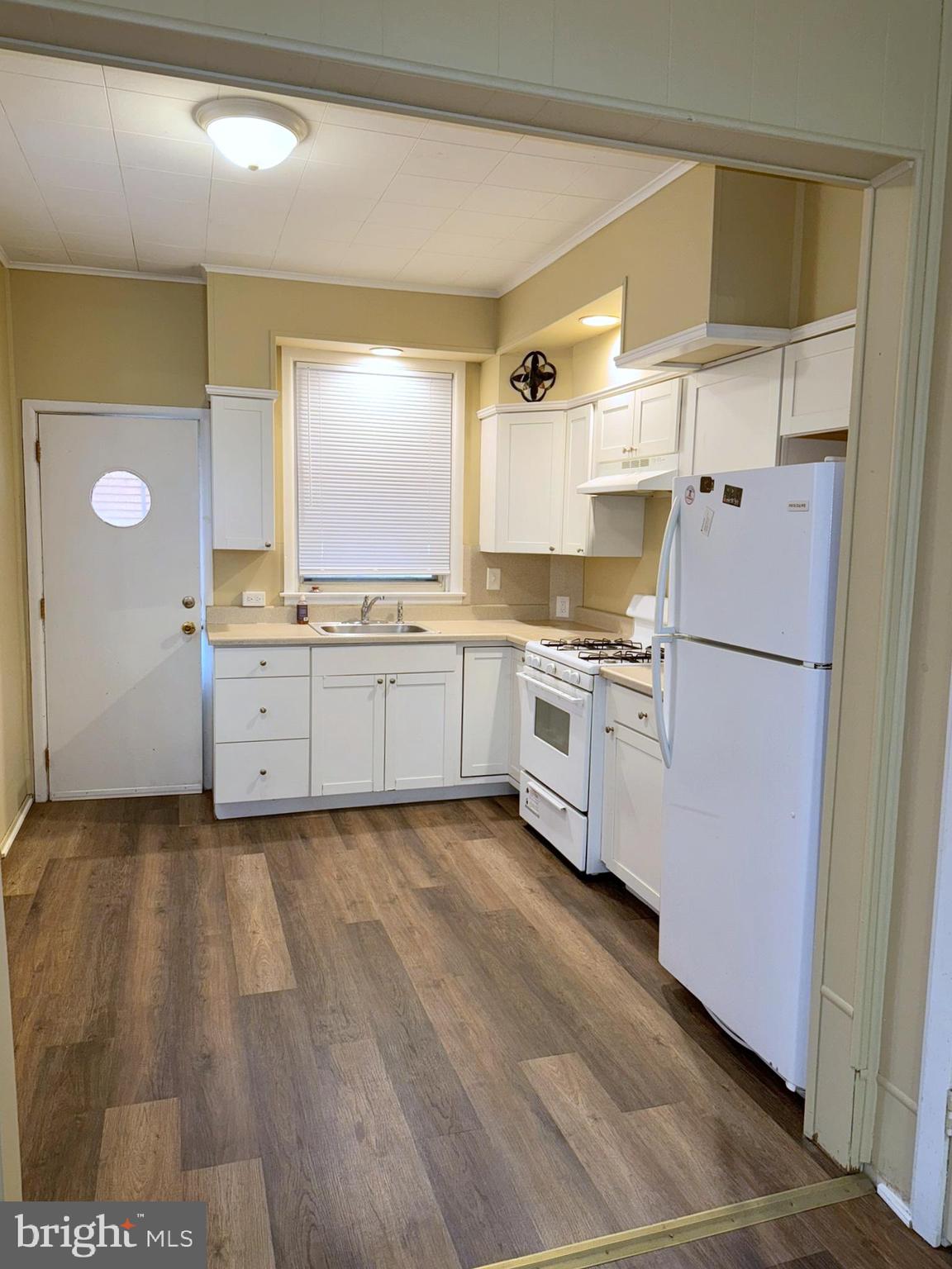 2246 South Bucknell Street Philadelphia, PA 19145 - Photo 4 of 25 a kitchen with granite countertop a refrigerator a sink and white cabinets