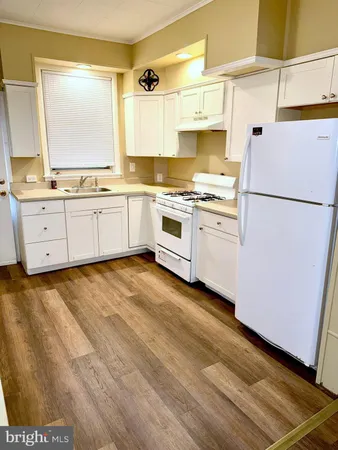 a kitchen with granite countertop white cabinets and white appliances