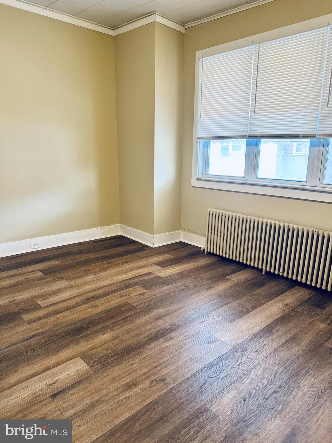 2246 South Bucknell Street Philadelphia, PA 19145 - Photo 9 of 25 a view of an empty room with wooden floor and a window