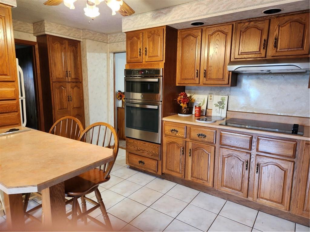 221 Meadowview Drive Latrobe, PA 15650 - Photo 3 of 15 a kitchen with stainless steel appliances granite countertop a refrigerator a stove a sink dishwasher and wooden cabinets with a dining table