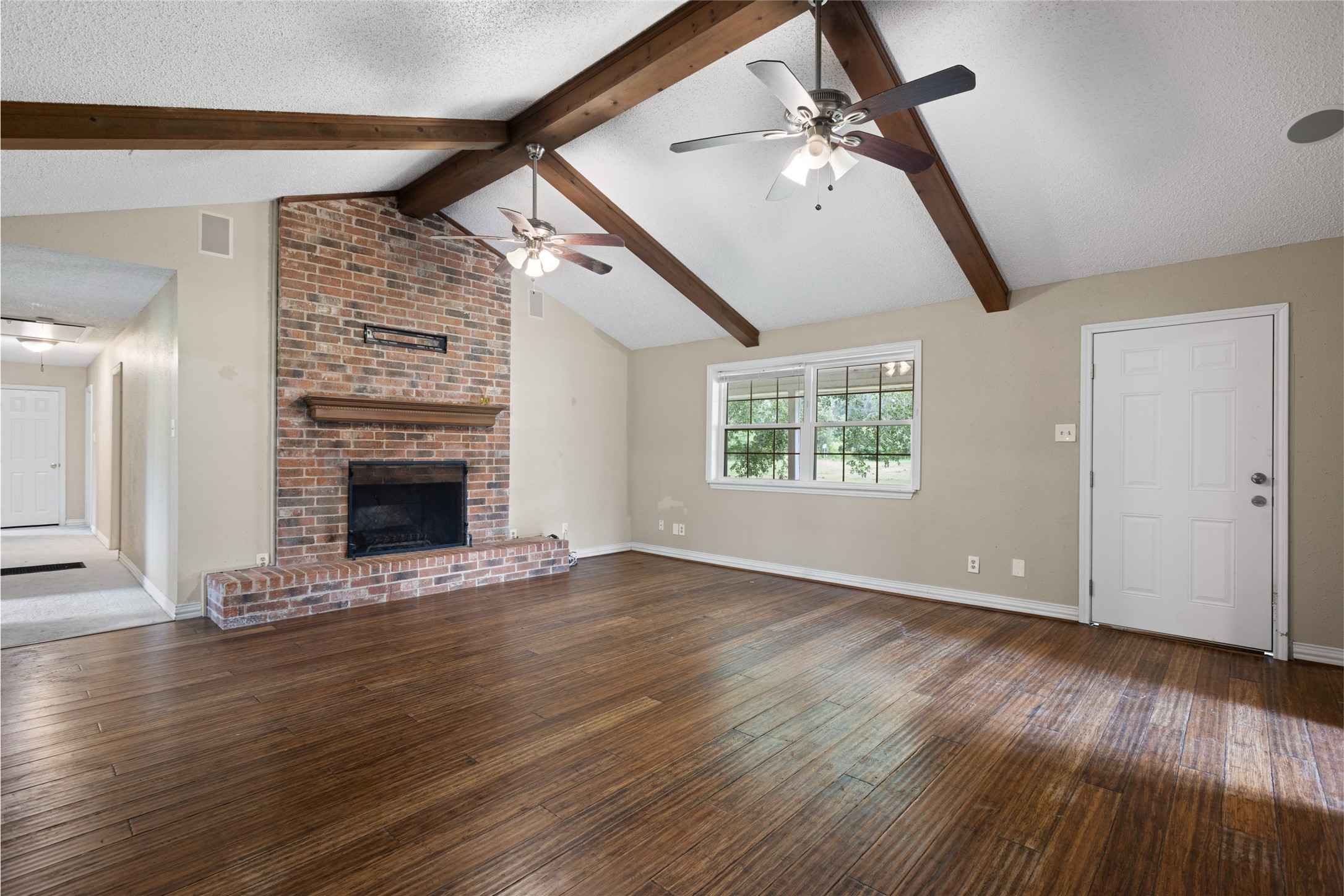 27093 Frye Road Splendora, TX 77372 - Photo 15 of 32 an empty room with wooden floor fireplace and windows