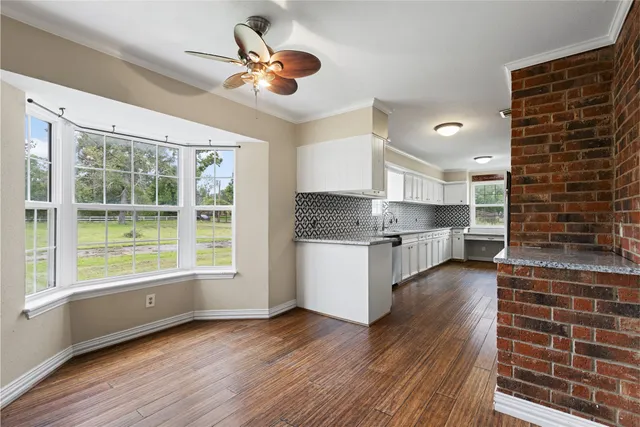 a kitchen with stainless steel appliances wooden floors and view living room