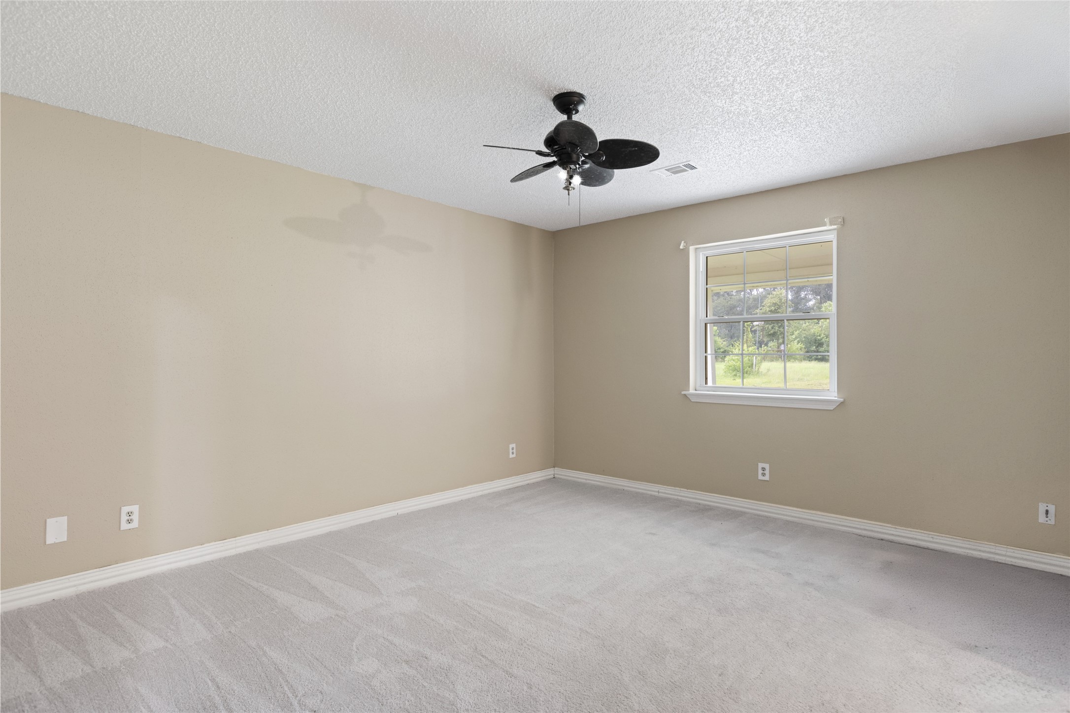 27093 Frye Road Splendora, TX 77372 - Photo 27 of 32 an empty room with a window and a fan