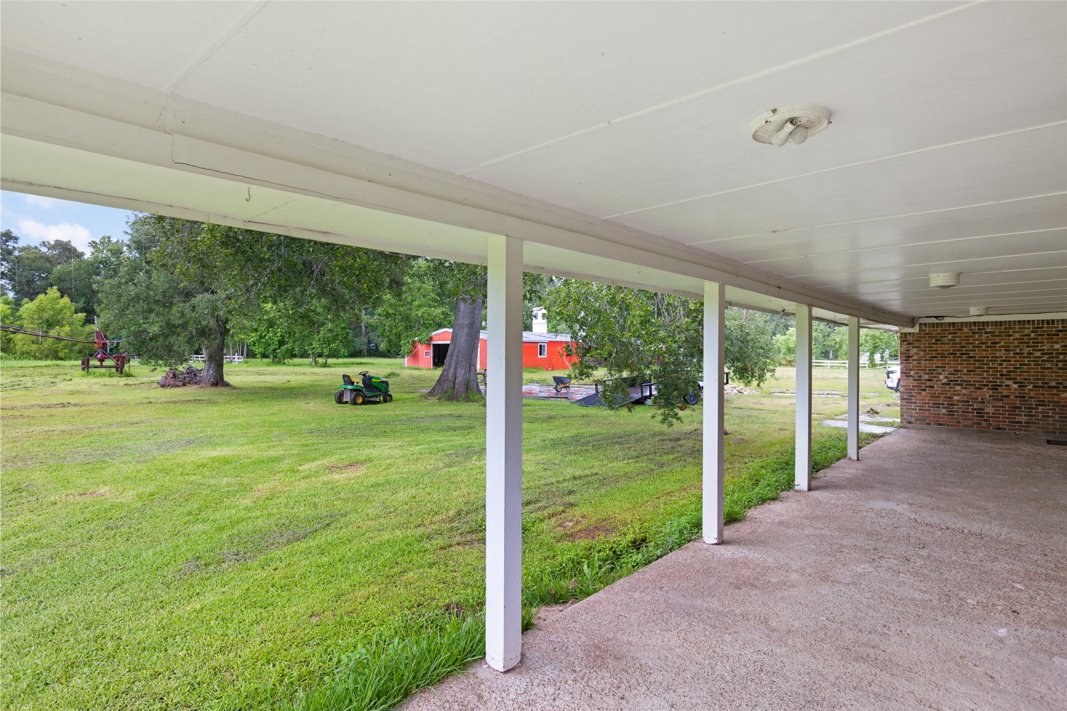 27093 Frye Road Splendora, TX 77372 - Photo 32 of 32 a view of a house with a big yard potted plants and palm trees