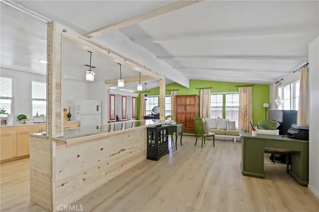 a large living room with stainless steel appliances kitchen island granite countertop furniture a large window and a sink