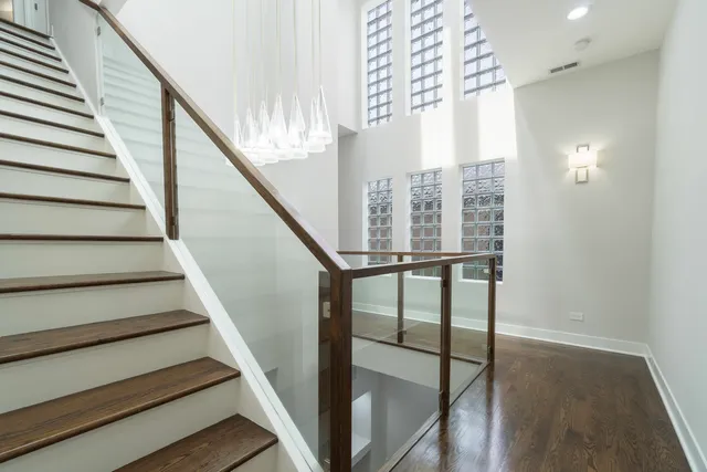 a view of staircase with wooden floor and white walls