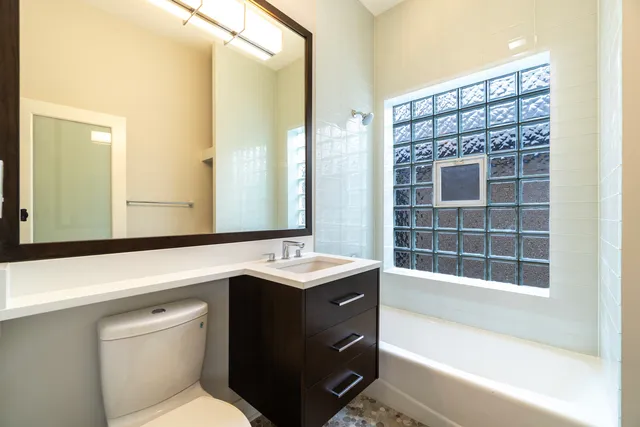 a bathroom with a bathtub sink and mirror