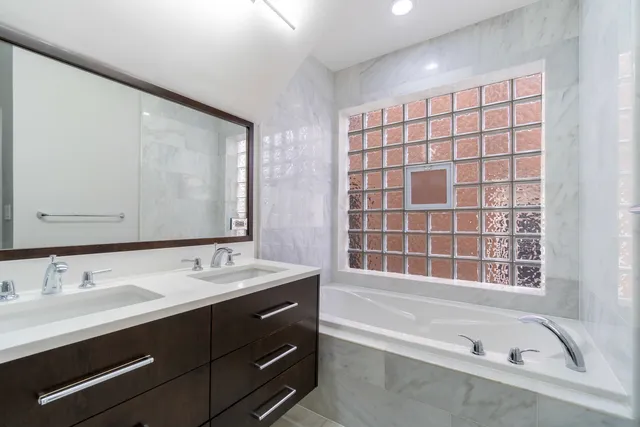 a bathroom with a bathtub sink and mirror