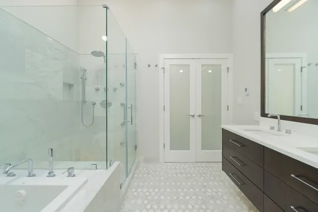 a spacious bathroom with a double vanity sink mirror and shower