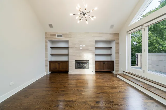a view of a room with a large window and wooden floor