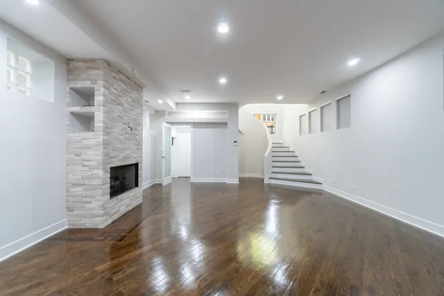 a view of a livingroom with wooden floor and staircase