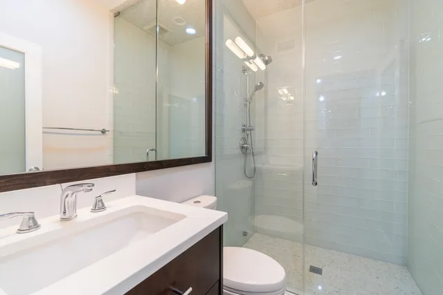 a bathroom with a sink a toilet and shower